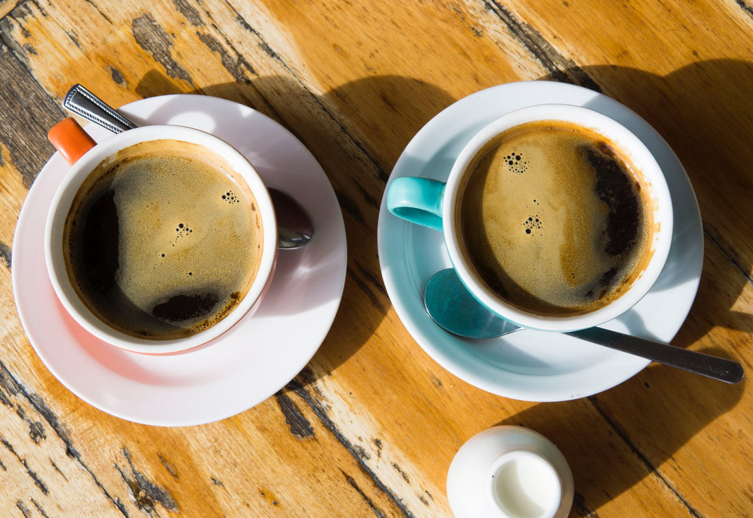 Two coffee cups on wood table
