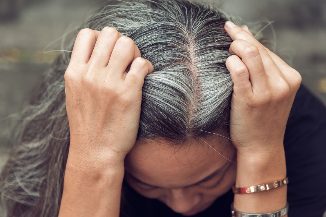 graying hair women holding her head