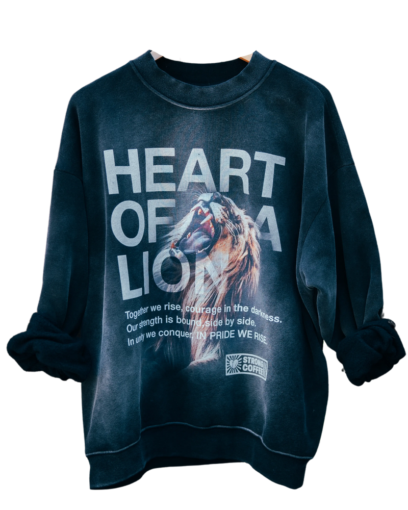 A black crew neck sweatshirt with a graphic print of a lion and the phrase 'HEART OF A LION' on the front.